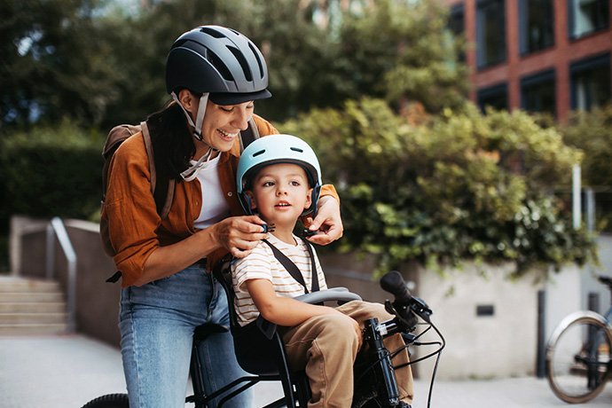 decorative image of a parent helping a child ride a bike