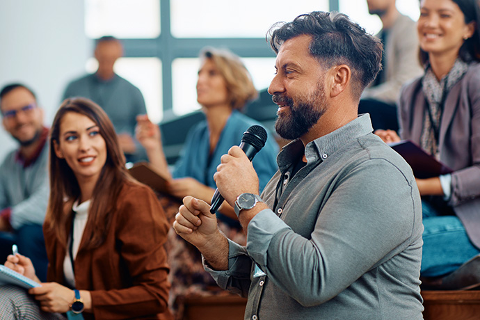 decorative image, a man talking in front of a crowd