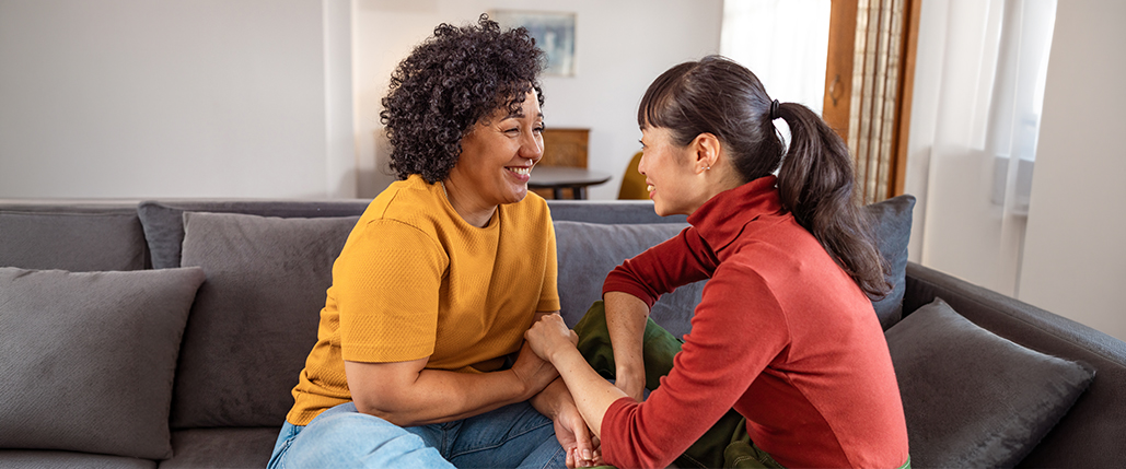 Two women talking and sitting on the couch